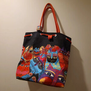 Laurel Burch cats Drawstring bag with a  wooden cube on the handle.